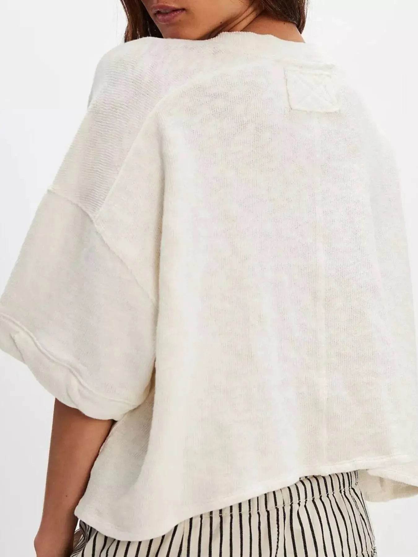 Women's oversized off-white half-sleeve cardigan with a textured shoulder patch.
