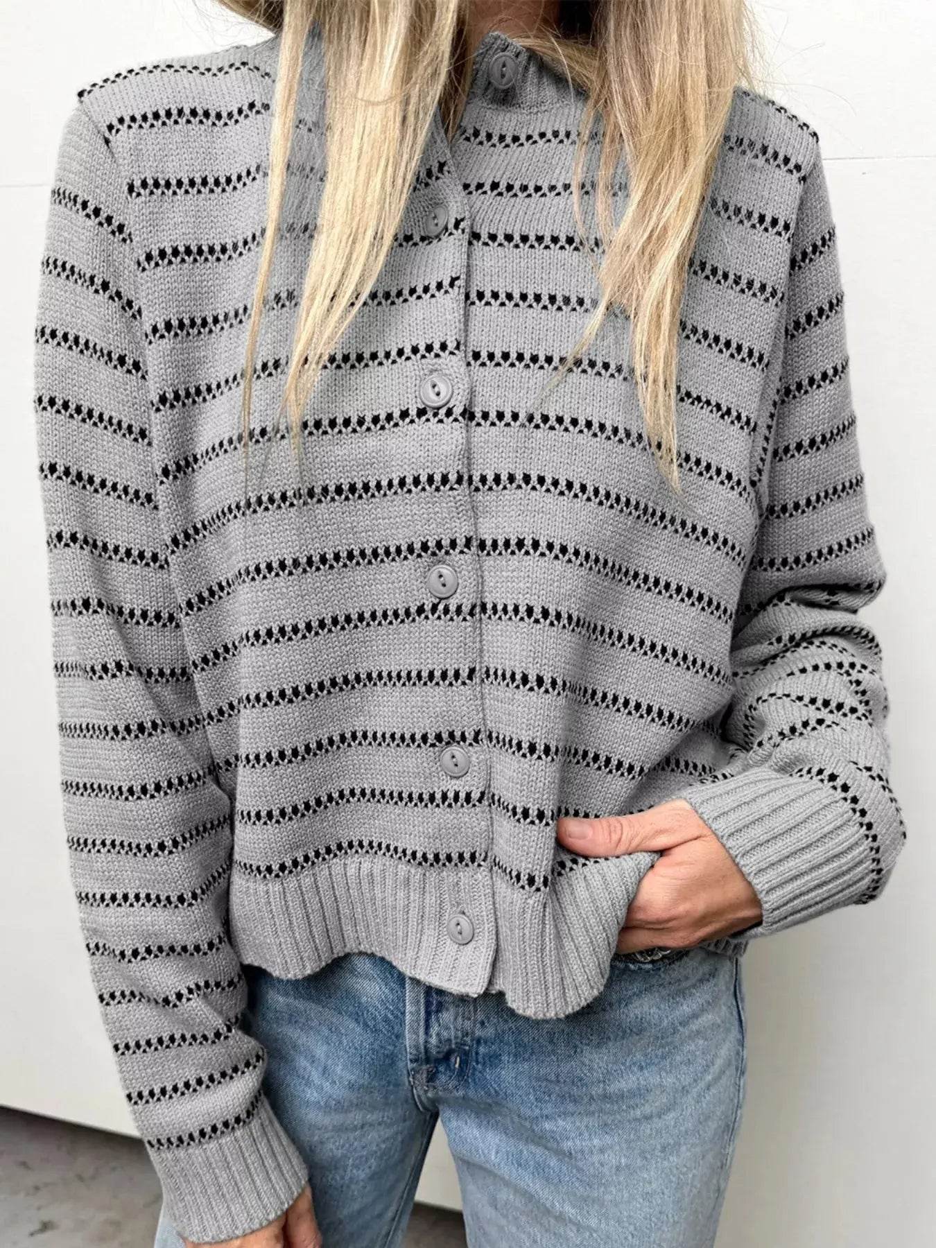 Women's gray striped button-up cardigan sweater with long sleeves and light wash jeans.