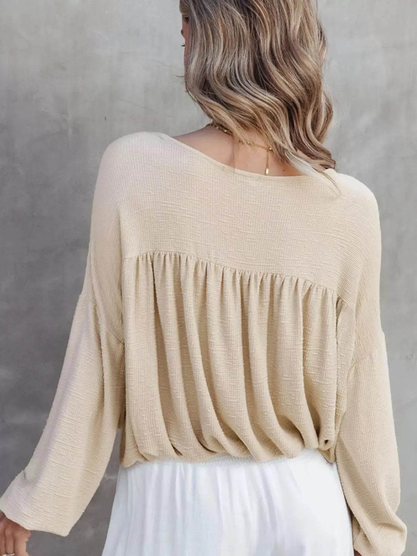 Textured drop shoulder long sleeve top with ruched back detail.