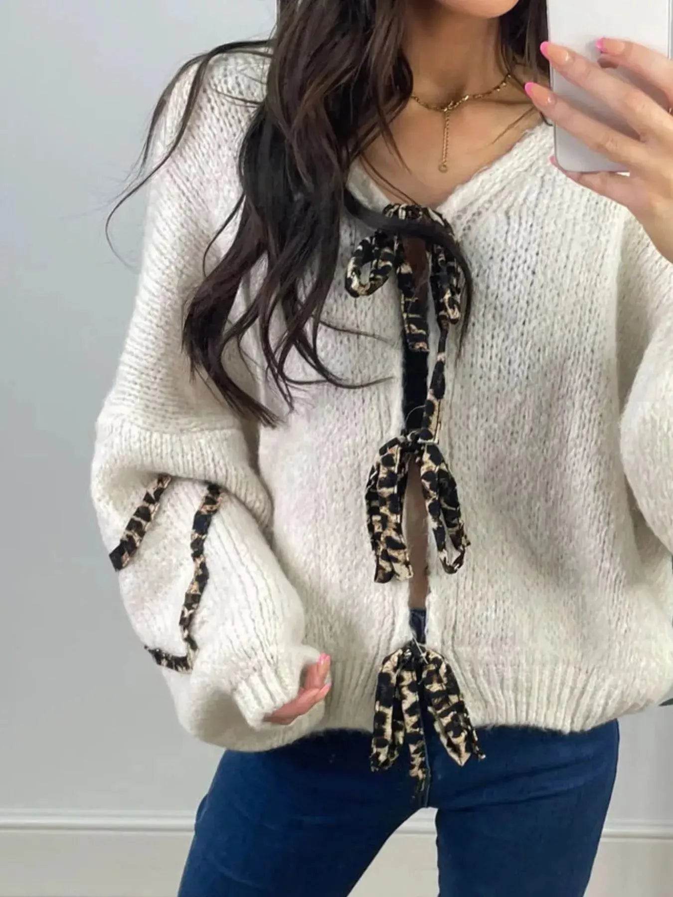White knit sweater with leopard print tie front and sleeve details.