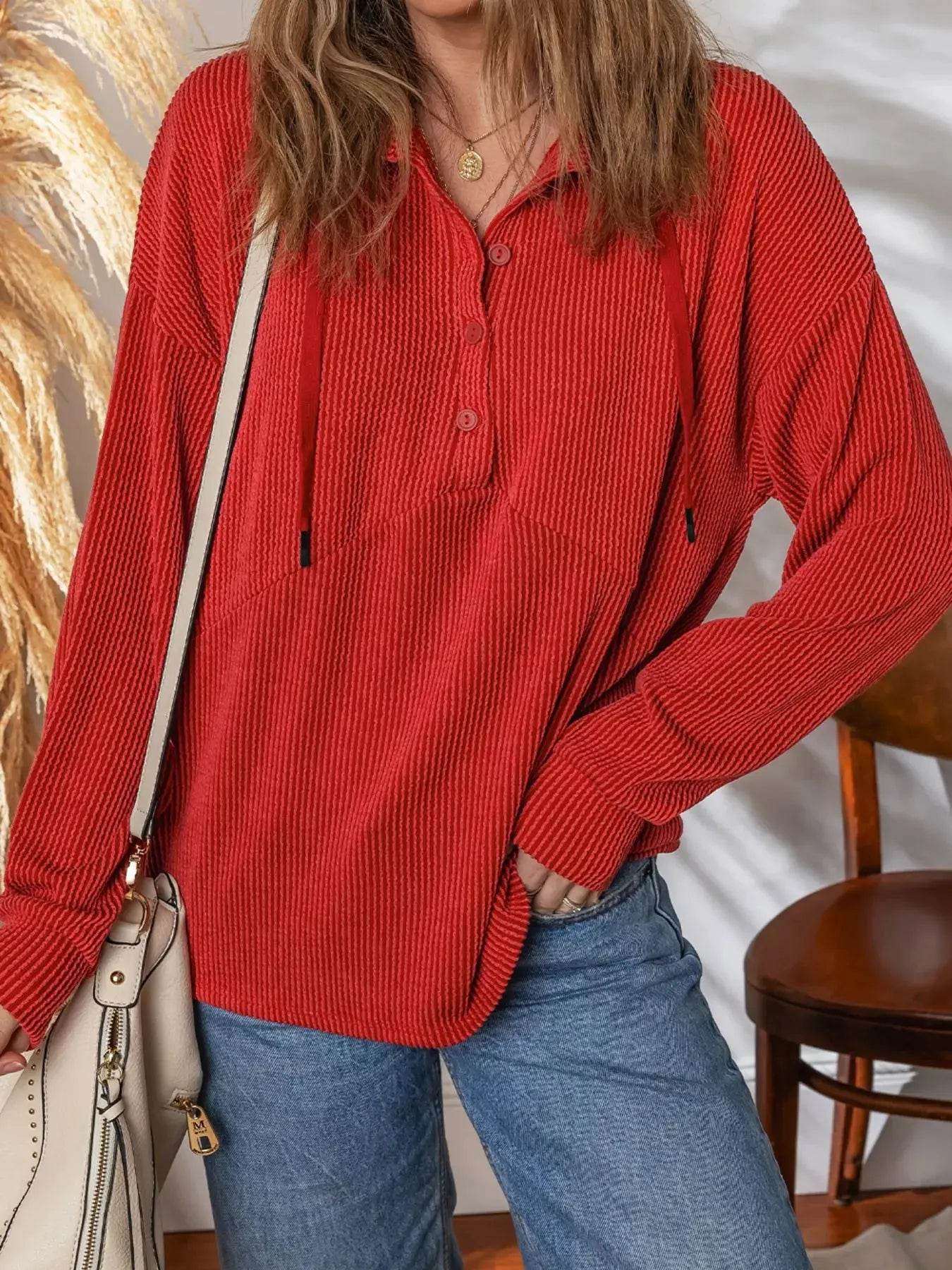 Red ribbed half-button collared drawstring top with long sleeves.